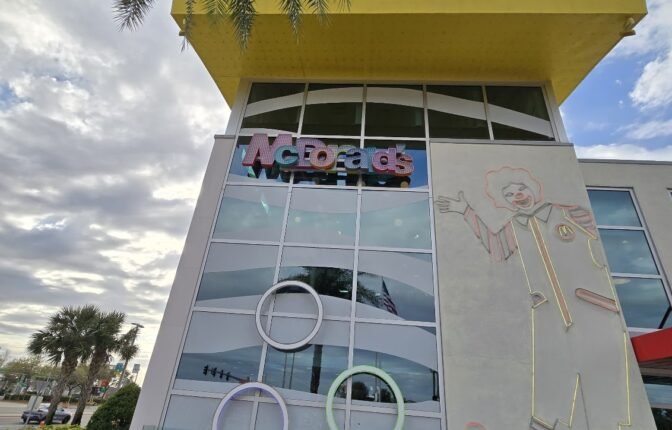 Exterior view of the World’s Largest McDonald’s in Orlando with Ronald McDonald outline and circular window design under a yellow roof