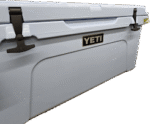 Close-up of YETI rotomolded coolers (pastel blue, neon yellow) on a store shelf, showing the T-latches and YETI logo