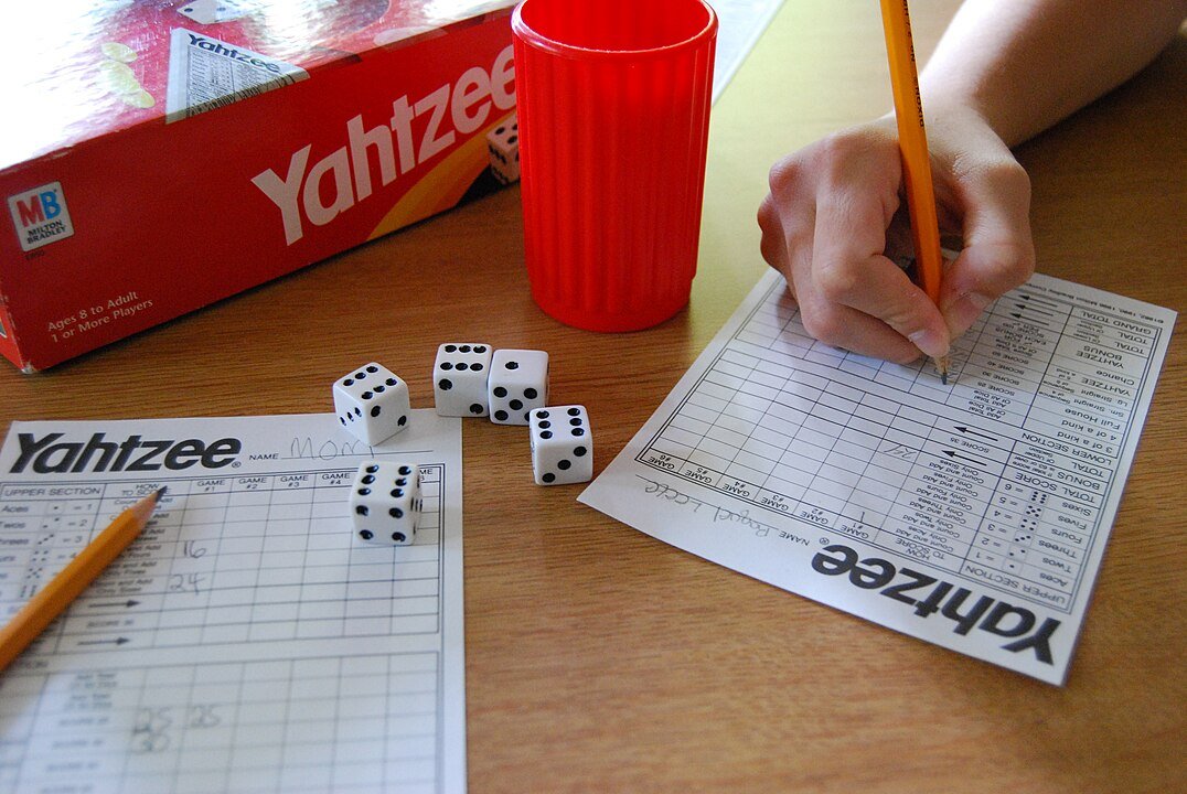 Yahtzee game box with score cards and die
