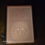Our Travel Bucket List journal with sun design on hardcover, sitting on wooden table