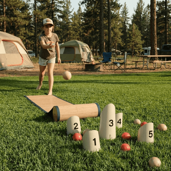 BocceRoll game set up on a sunny backyard lawn with wooden ramp and numbered targets