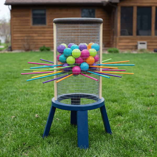 DIY giant Ker-Plunk game with wooden frame colorful balls and dowel rods on a backyard lawn