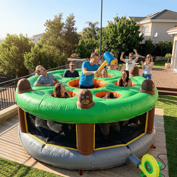 Giant inflatable human whack a mole game set up outdoors at a family party