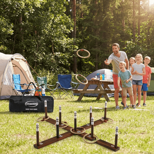 Wooden ring toss game set up at a campsite with rope rings and numbered stakes
