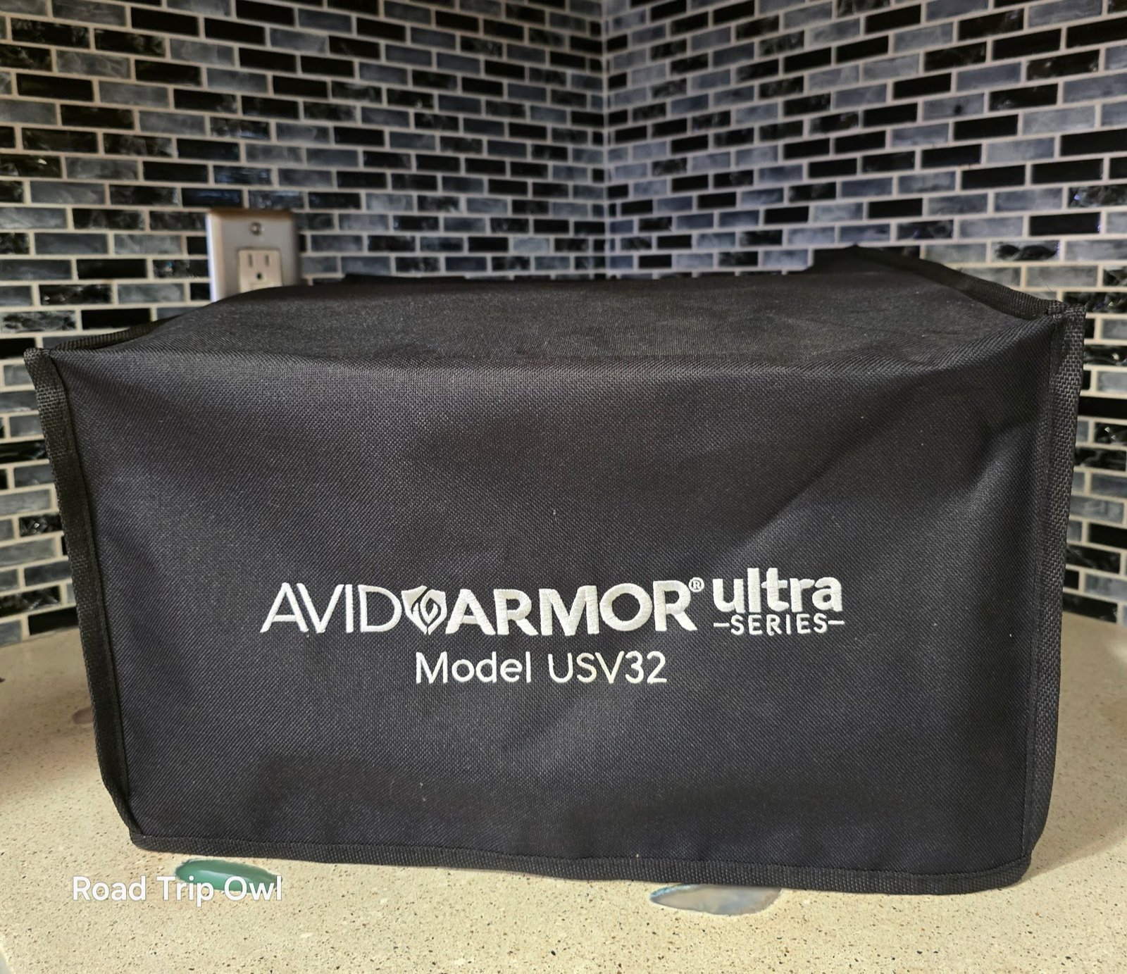 Avid Armor USV32 chamber vacuum sealer with black branded counter cover on kitchen counter