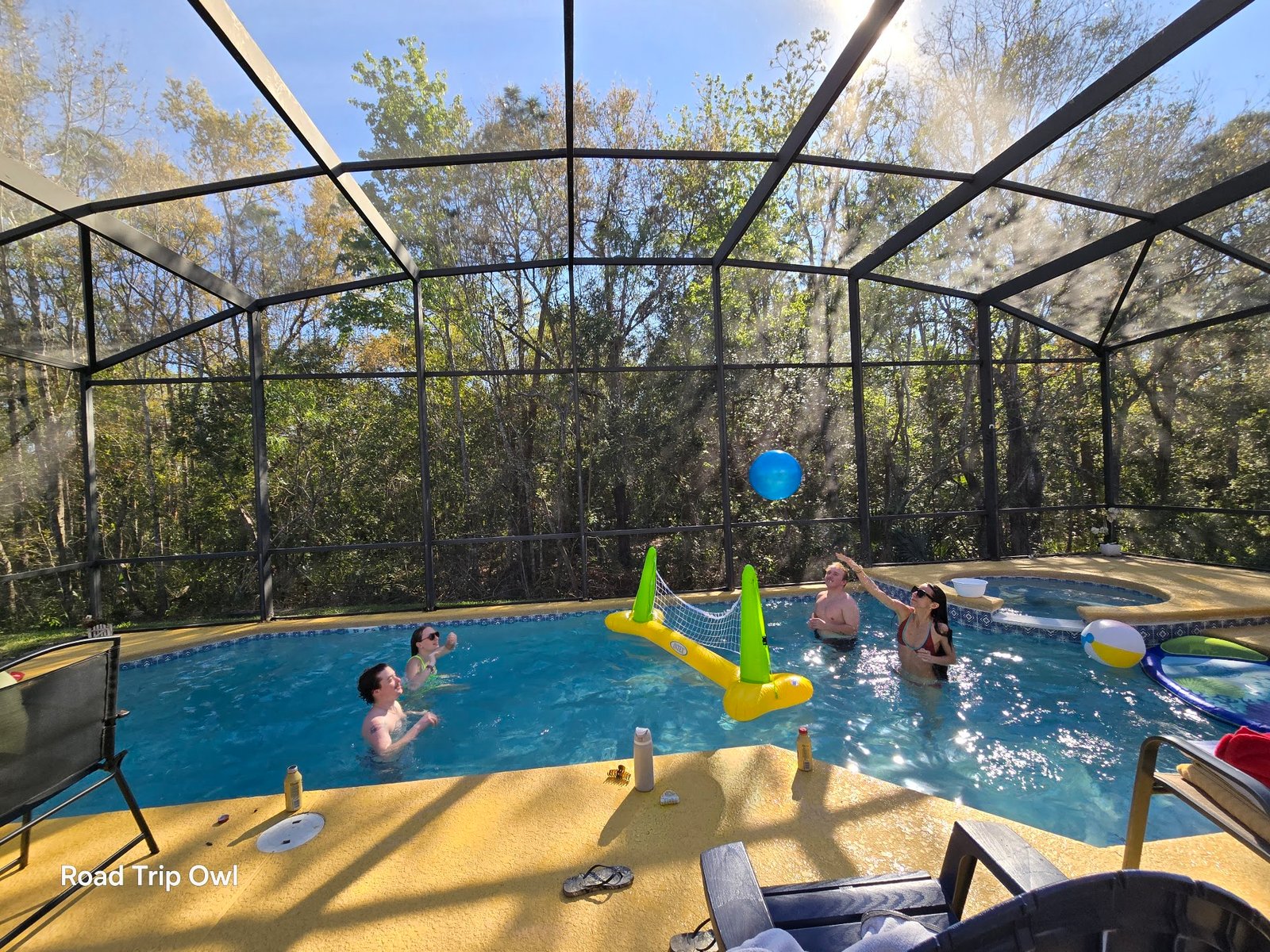 A family playing pool volleyball in a screened Florida vacation rental — the kind of easy, unstructured family time that makes a first vacation feel like a success.