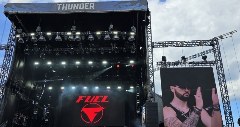 Music festival crowd with hands raised in front of stage